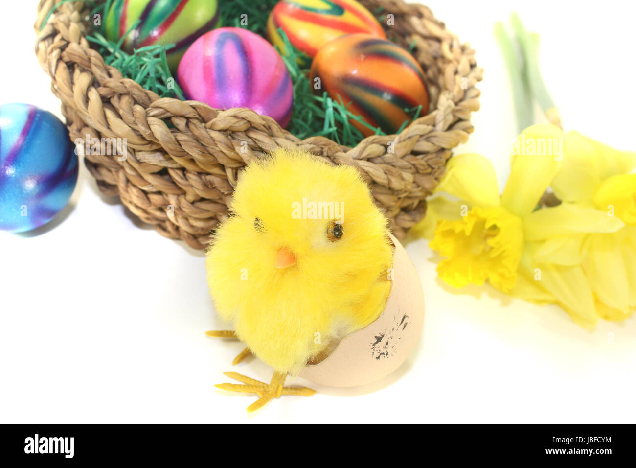 Osternest mit Küken und bunten Eiern auf hellem Hintergrund Stock Photo