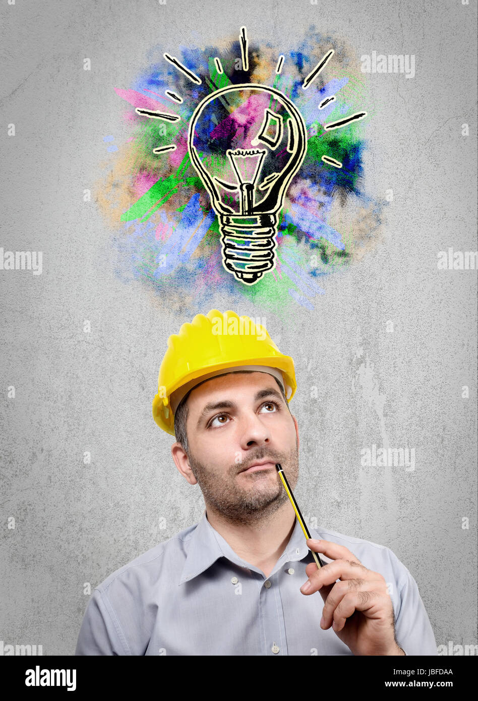 Engineer with a helmet on his head, reflecting staring into the void holding a pencil under her nose Stock Photo