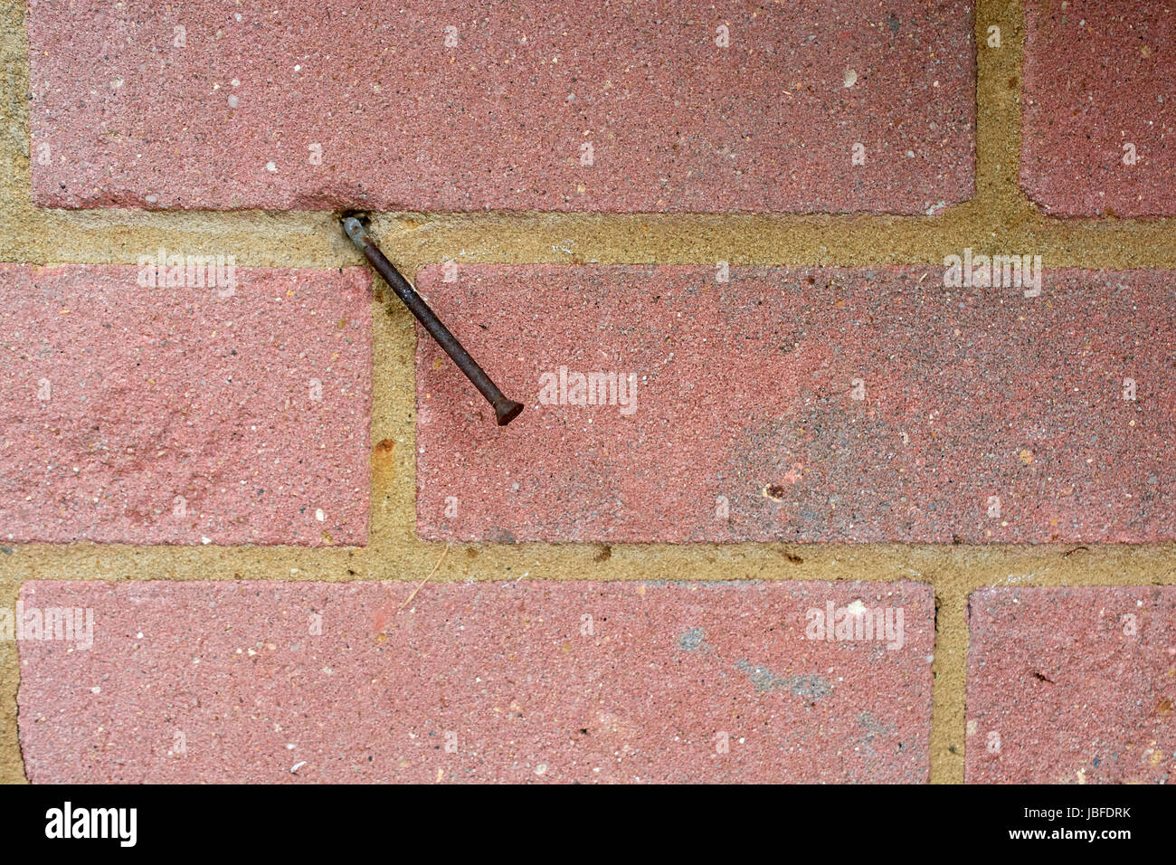 Rusty bent nail in red brick wall Stock Photo Alamy
