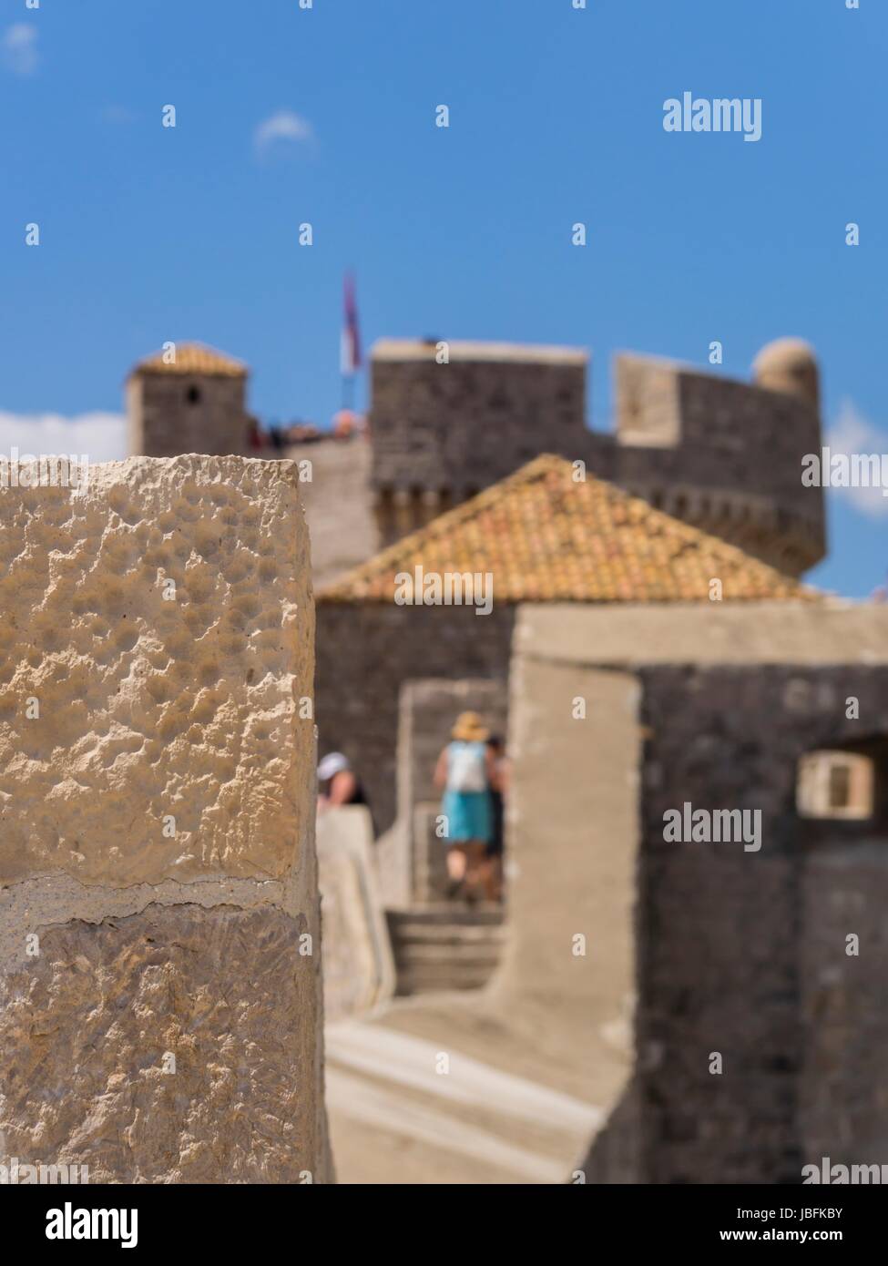 Dubrovnik wall visitors tourists blurred out of focus in background image focused on wall Stock Photo