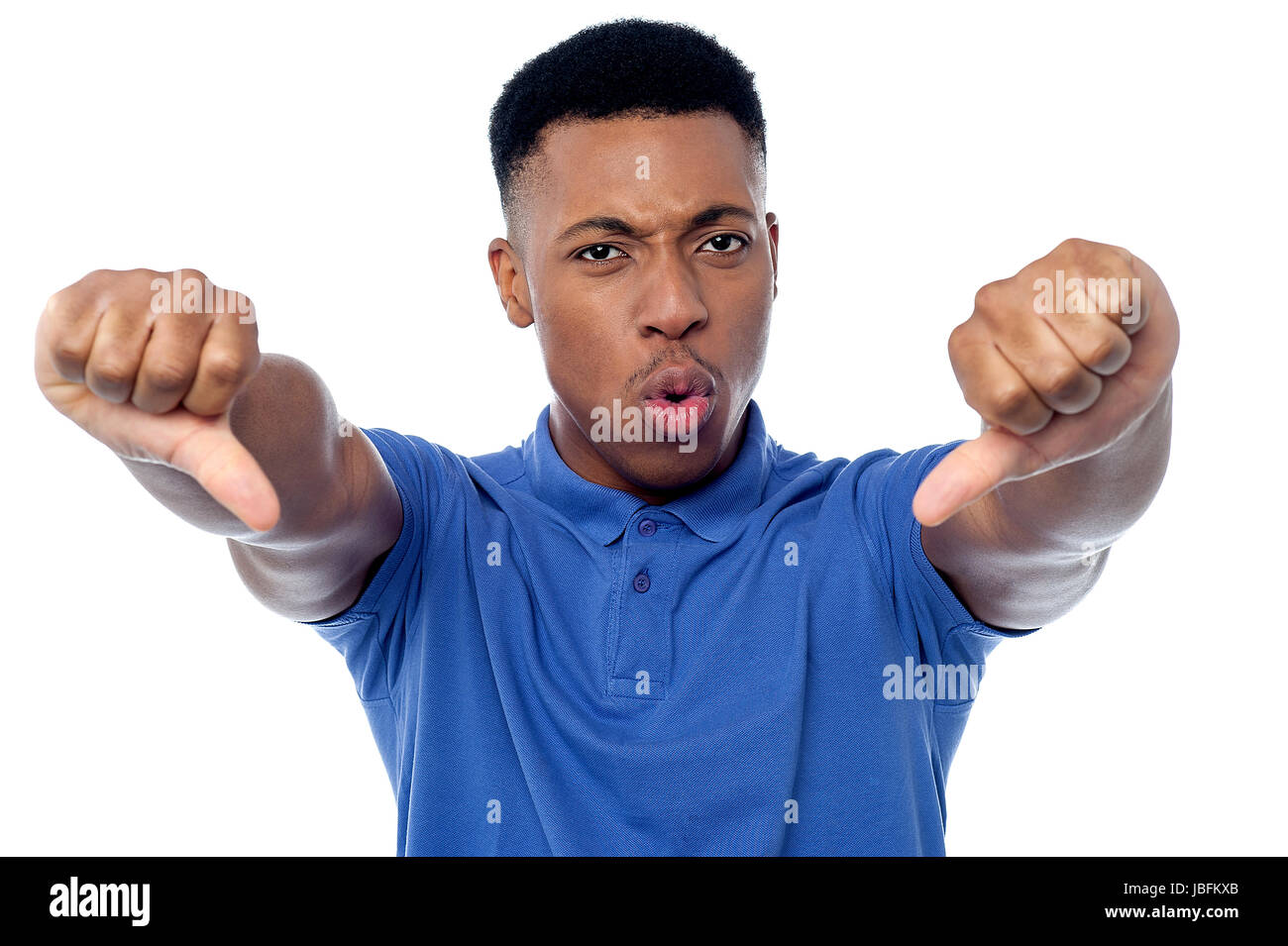Handsome young guy showing double thumbs down Stock Photo - Alamy