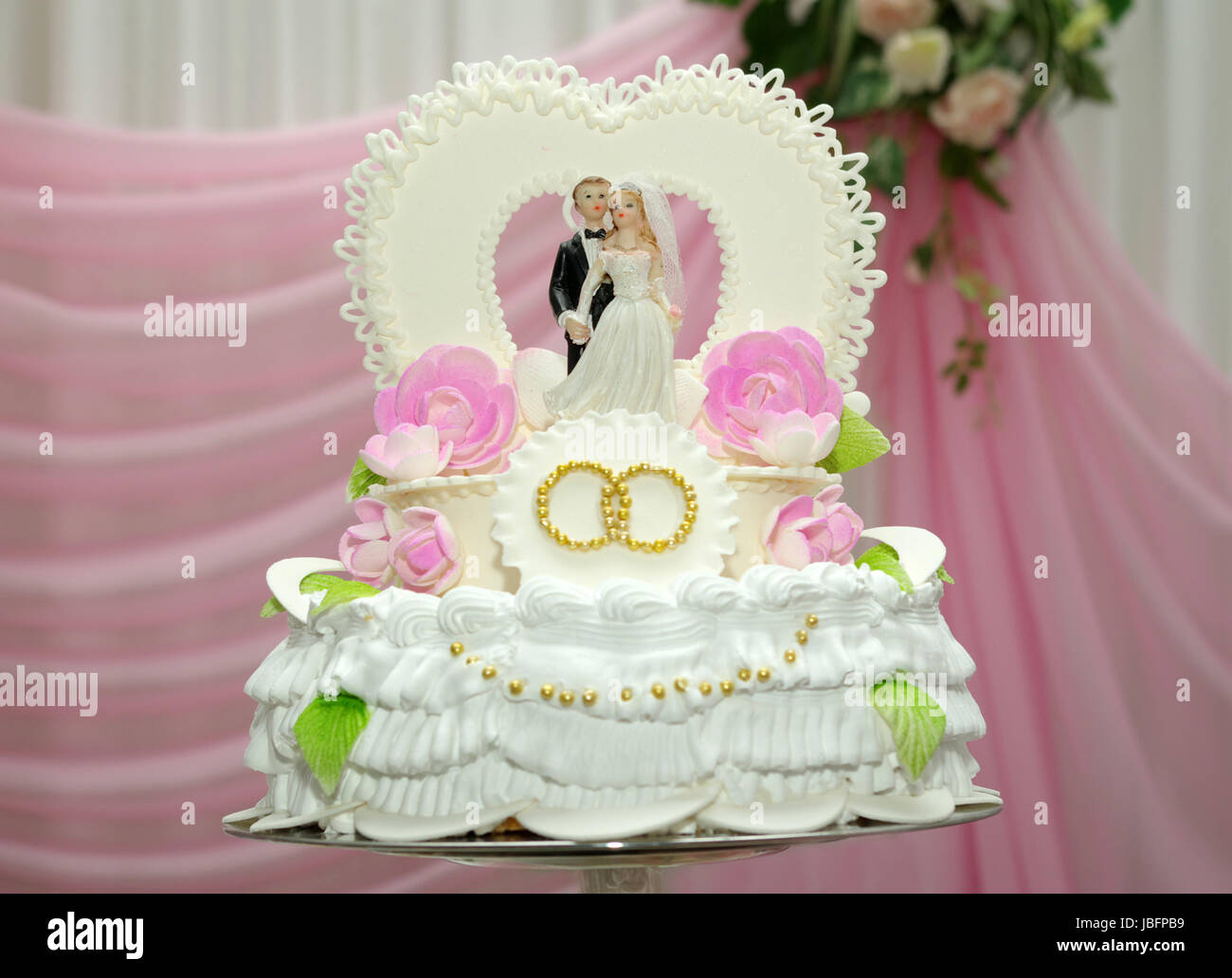A wedding cake with pink background Stock Photo - Alamy