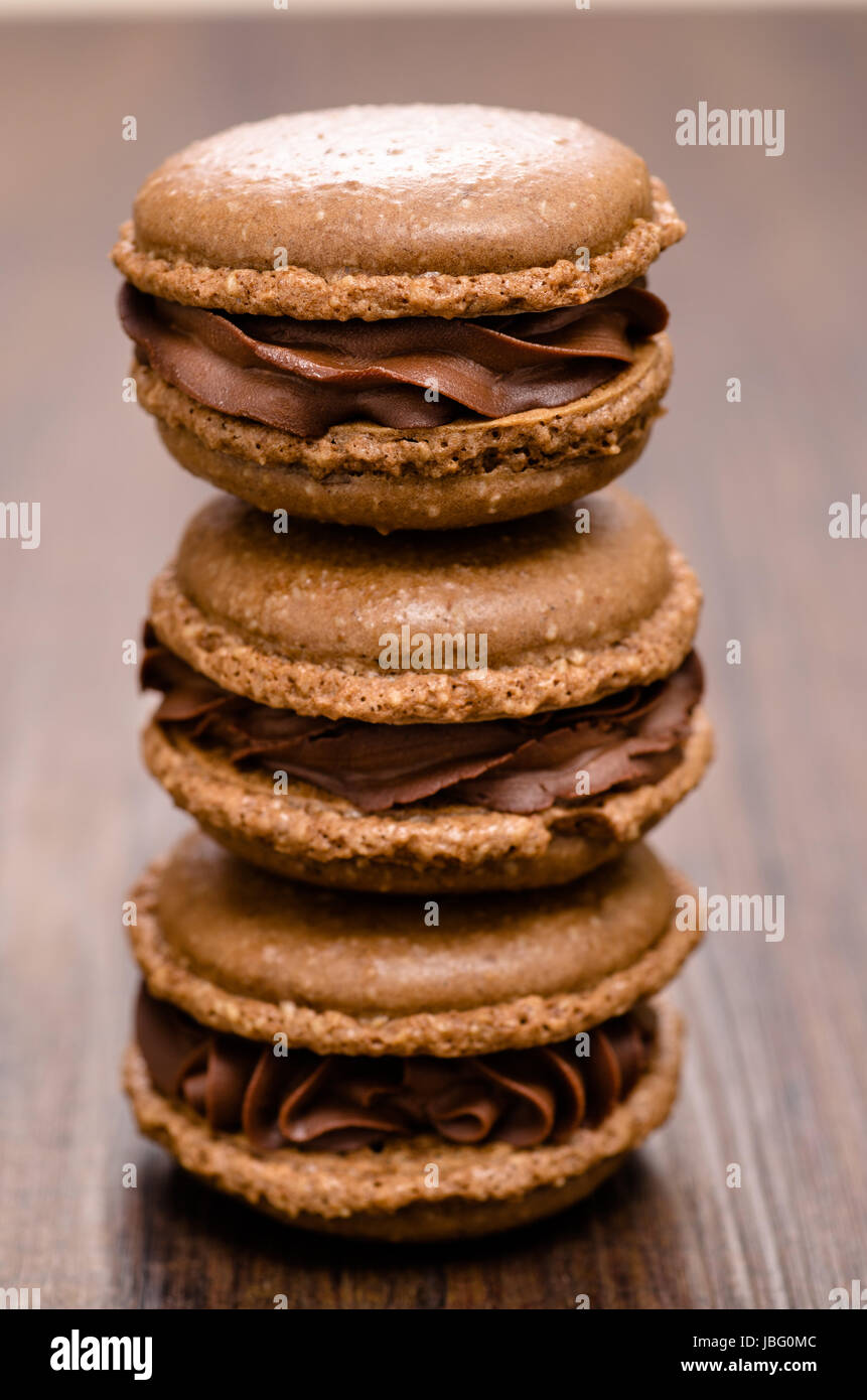 Drei braune Schokoladen Macarons auf einem Stapel Stock Photo