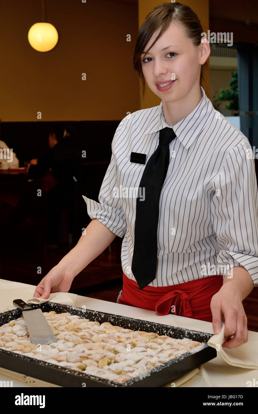 Restaurantfachfrau stellt Nachspeise zum Buffet Stock Photo