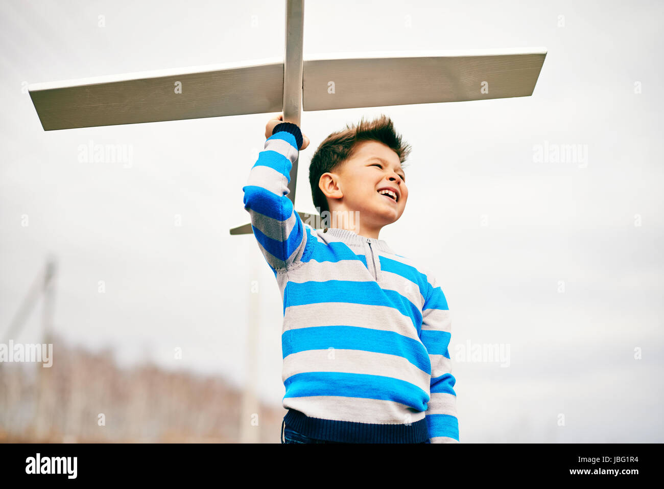 Photo of happy kid with toy airplane outside Stock Photo - Alamy