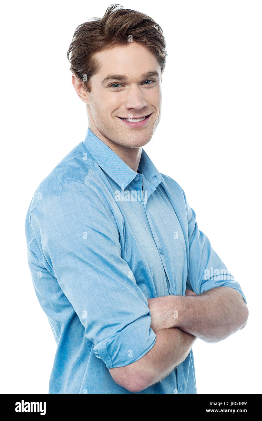 Young man looking at camera with arms crossed Stock Photo - Alamy