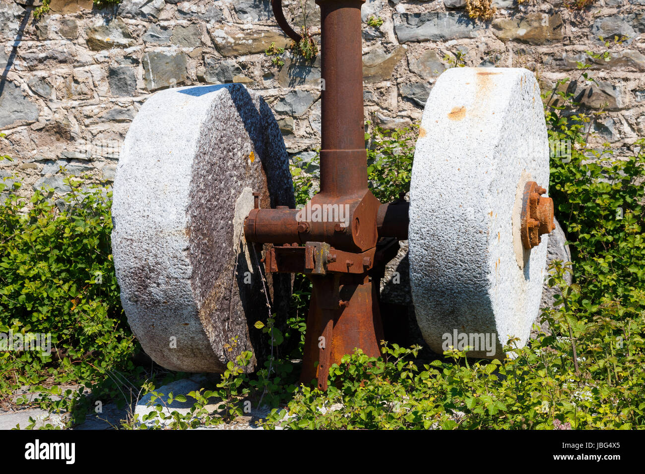 An old olive press with two millstones used for olive oil production in Greece.  People have used olive presses since Greeks first began pressing oliv Stock Photo
