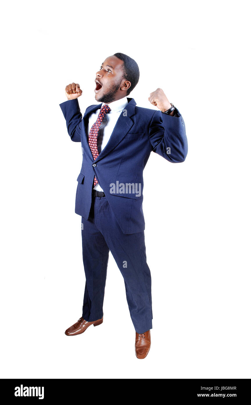 A young black business man standing in a suit and tie, holding up his ...