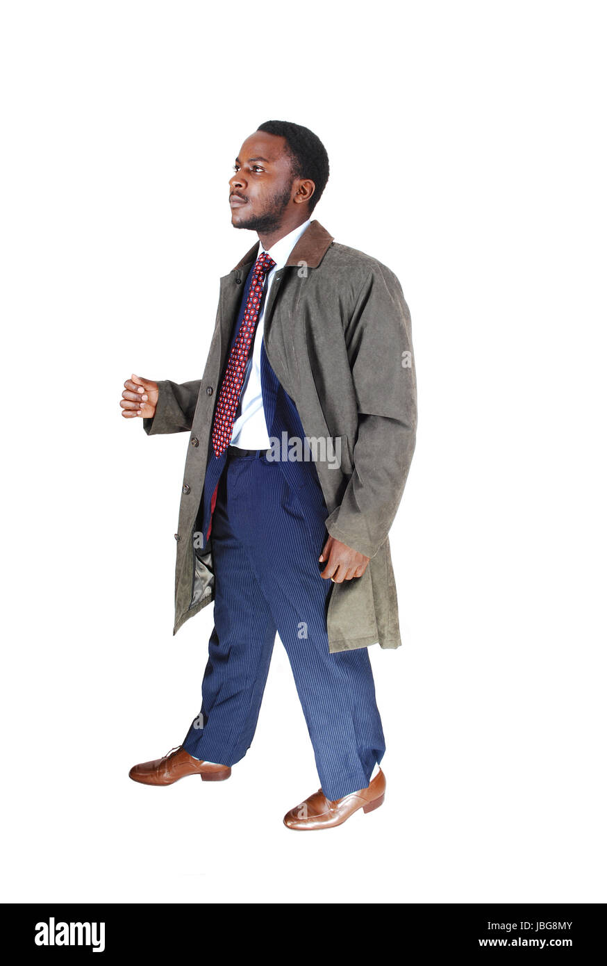 A young African American man in a blue suit and tie with a grey coat ...