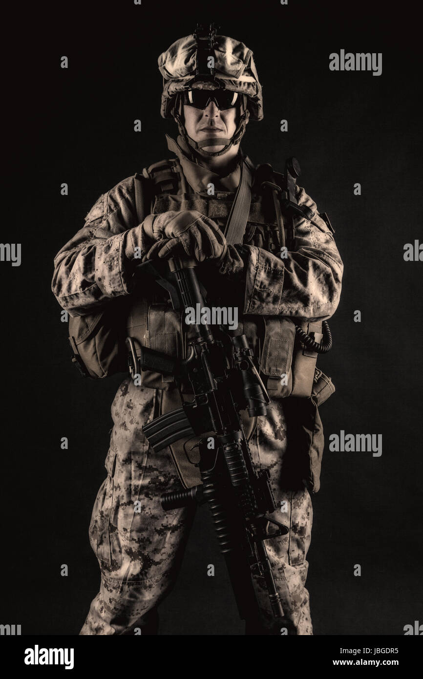 US marine with his assault rifle on black background Stock Photo - Alamy
