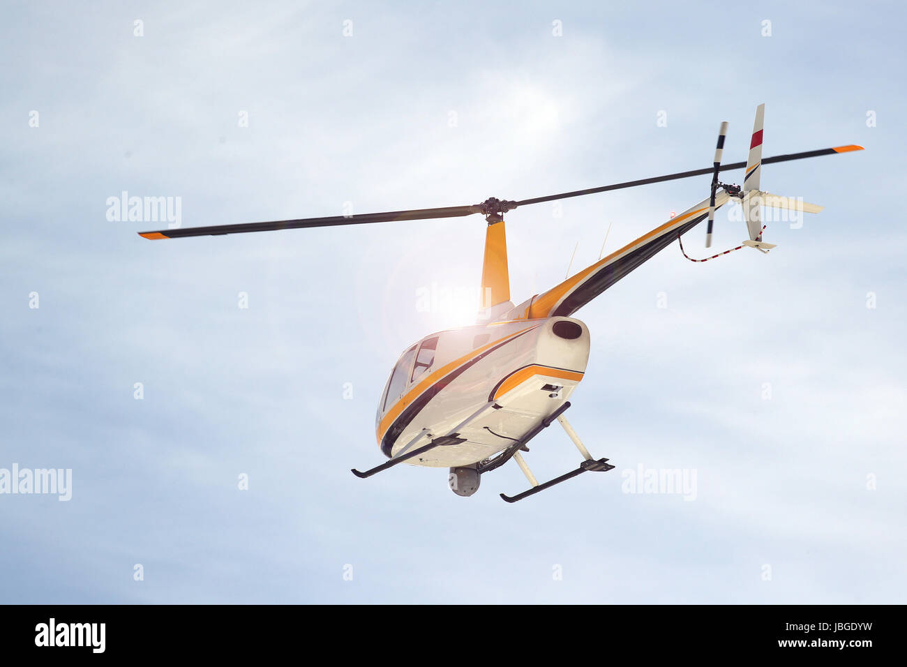 Helicopter in flight against the sun Stock Photo