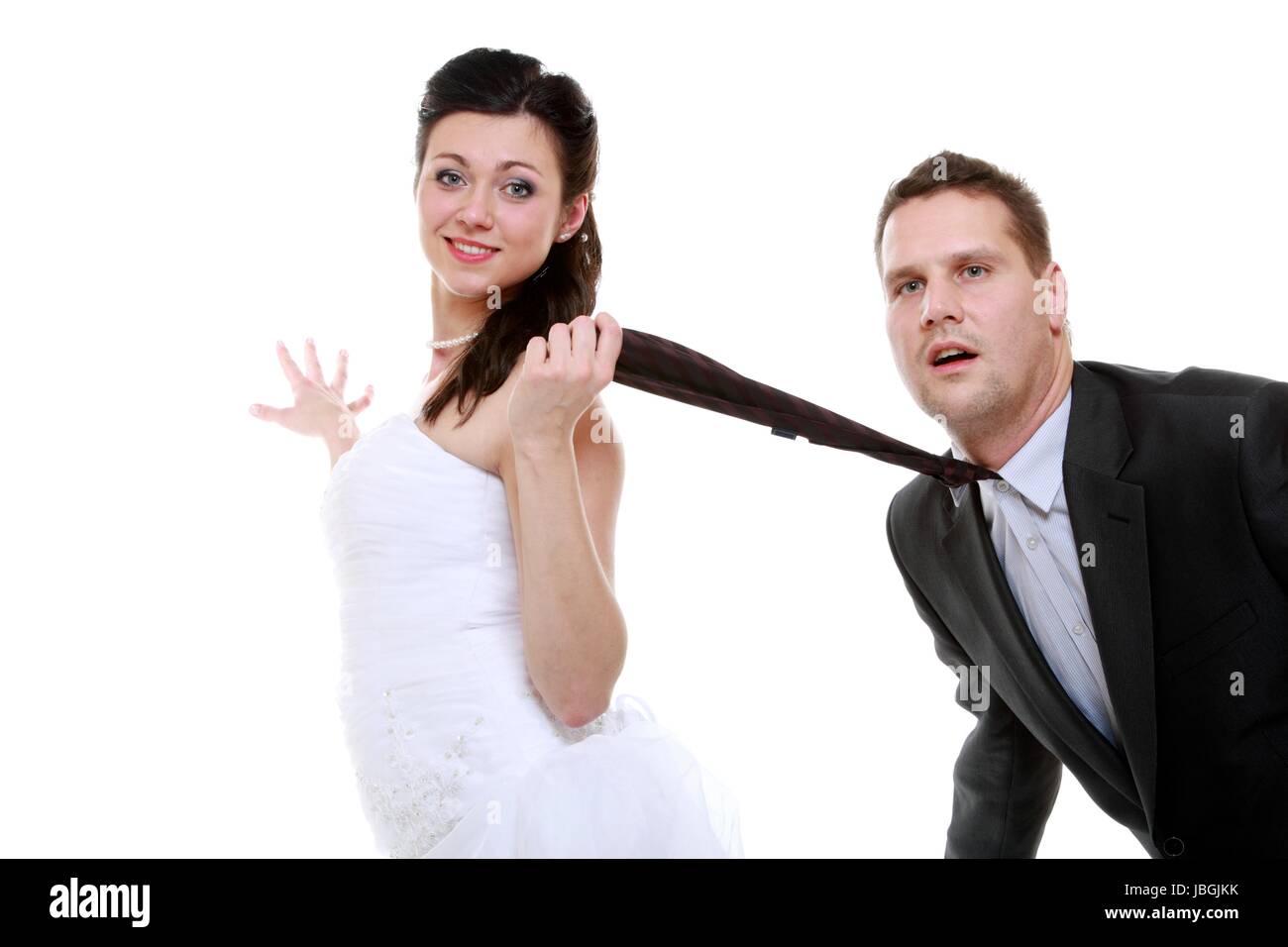 Emancipation idea concept. Humorous funny wedding couple bride and groom -  woman pulling the tie of a man, trying to show her domination, isolated  Stock Photo - Alamy