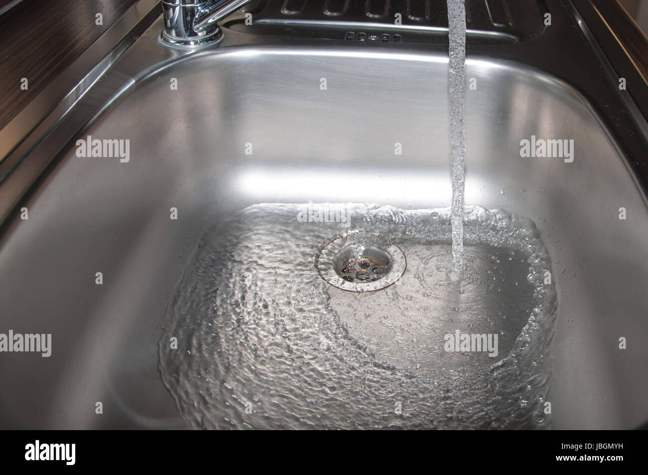 Stainless steel sink plug hole close up with water Stock Photo Alamy