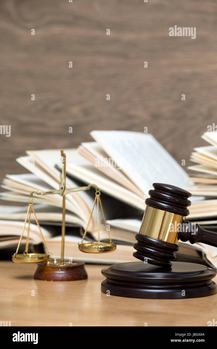 Wooden gavel, golden scales of justice and books on wood background ...