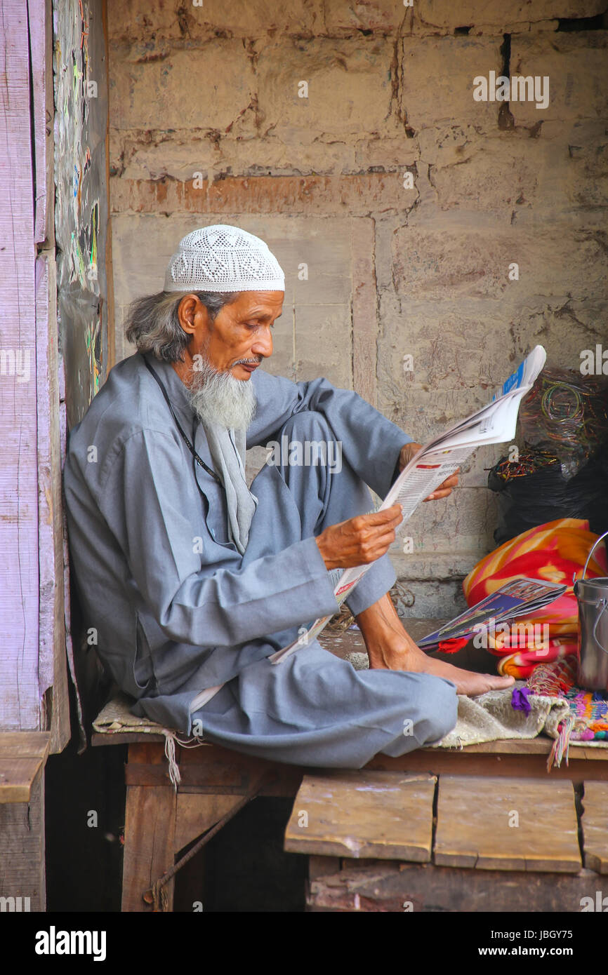 Local man reading newspaper at the street market in Fatehpur Sikri, Uttar Pradesh, India. The city was founded in 1569 by the Mughal Emperor Akbar, an Stock Photo