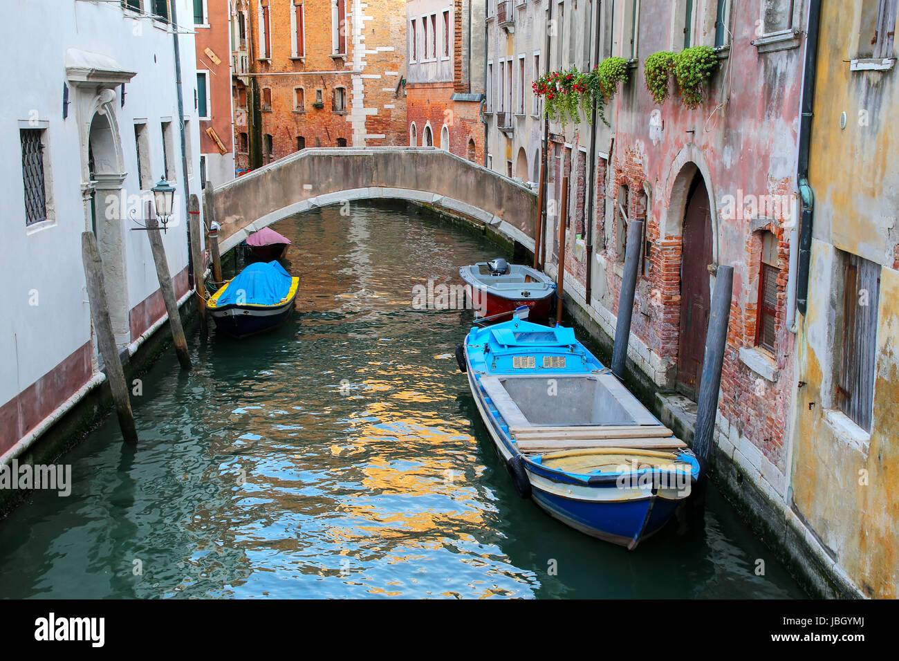 Boats moored in a narrow canal in Venice, Italy. Venice is situated across a group of 117 small islands that are separated by canals and linked by bri Stock Photo
