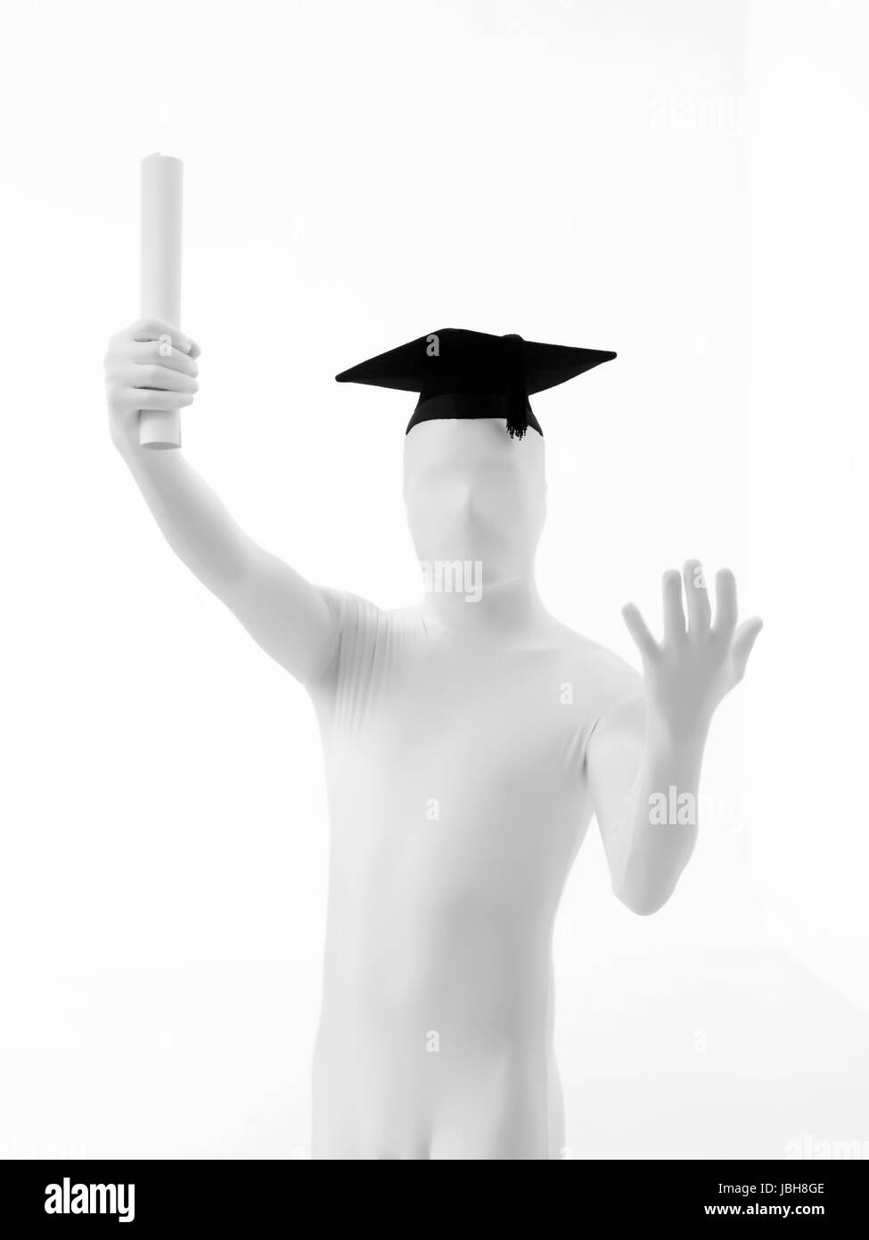 Unknown person dressed in black tie and white suit with graduate hat and diploma front view Stock Photo