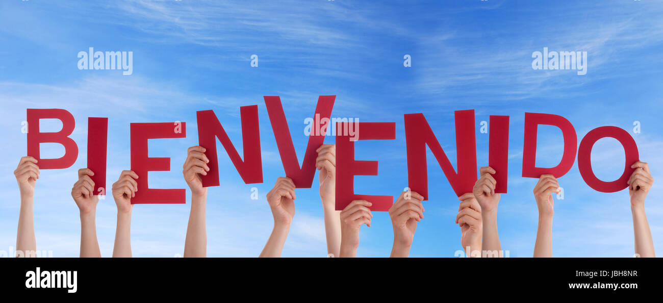 Many Hands Holding the Spanish Word Bienvenido in the Sky which means Welcome Stock Photo