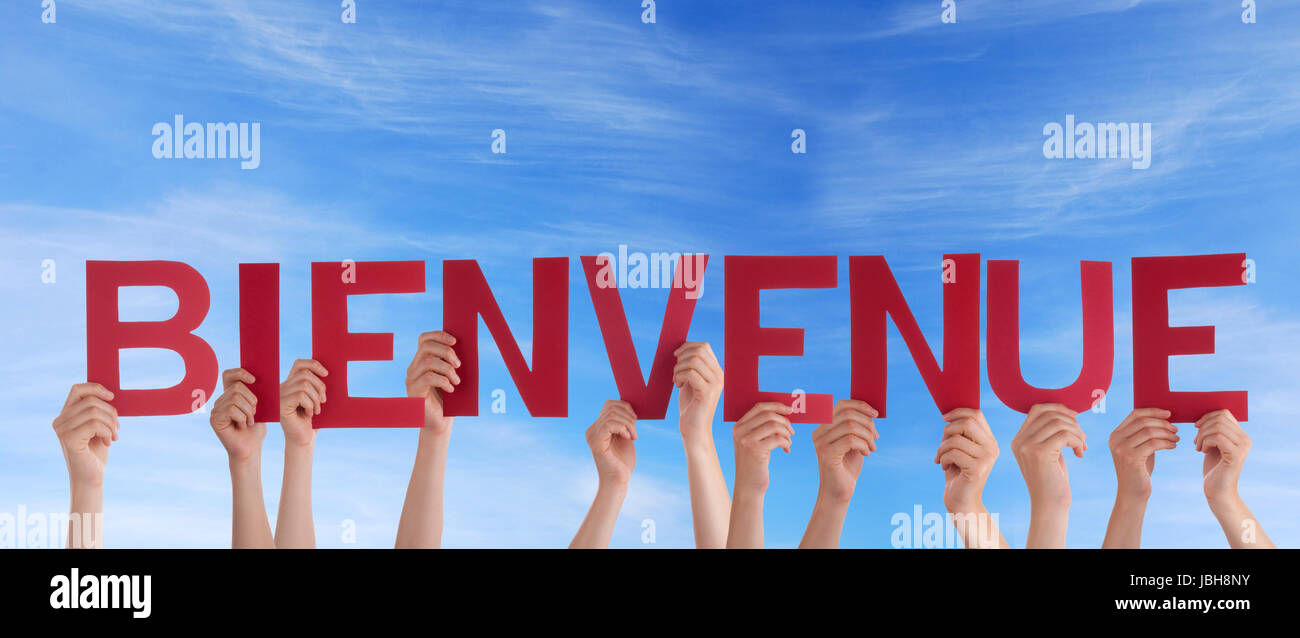 Many Hands Holding the French Word Bienvenue in the Sky which means Welcome Stock Photo