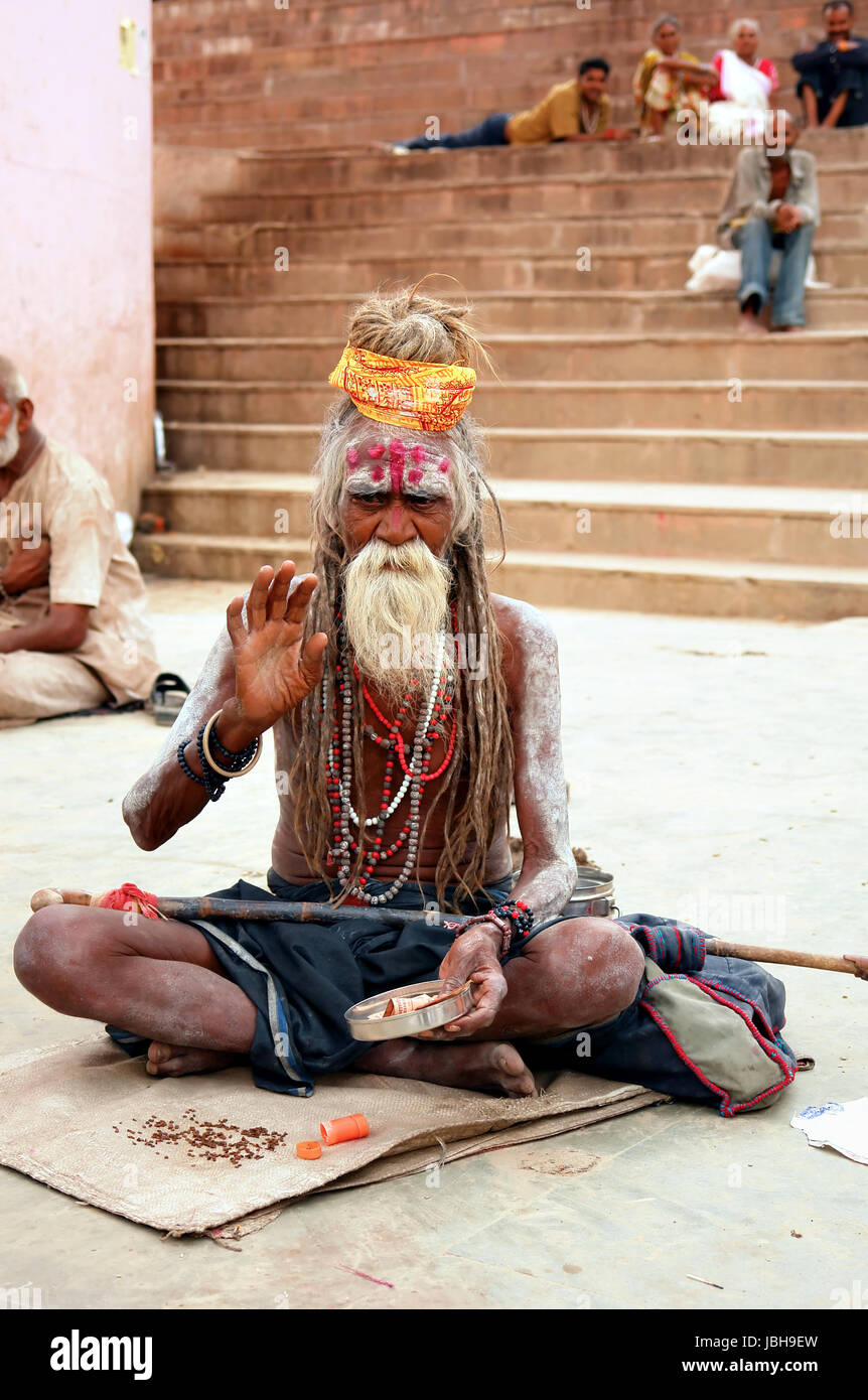 VARANASI, INDIA - SEPTEMBER 21, 2009: An Indian holy pilgrim sits on the banks of the Ganges in Varanasi. India. Stock Photo