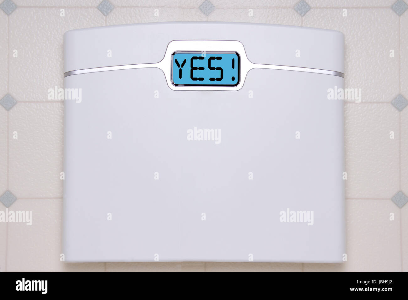 A white digital bathroom scale displaying the text message YES Stock ...