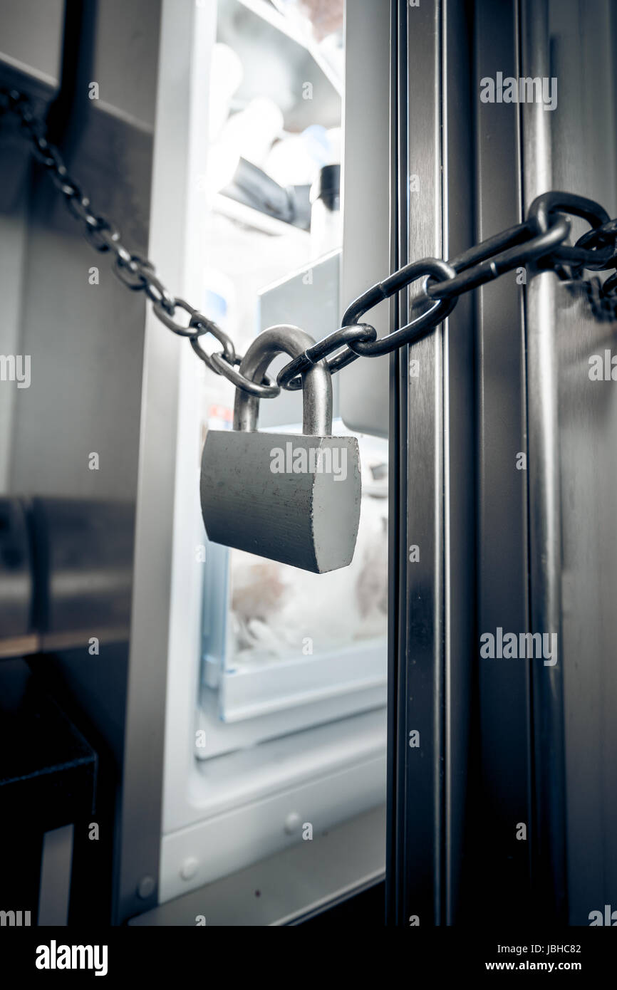 Closeup photo of metal lock hanging on refrigerator door Stock Photo