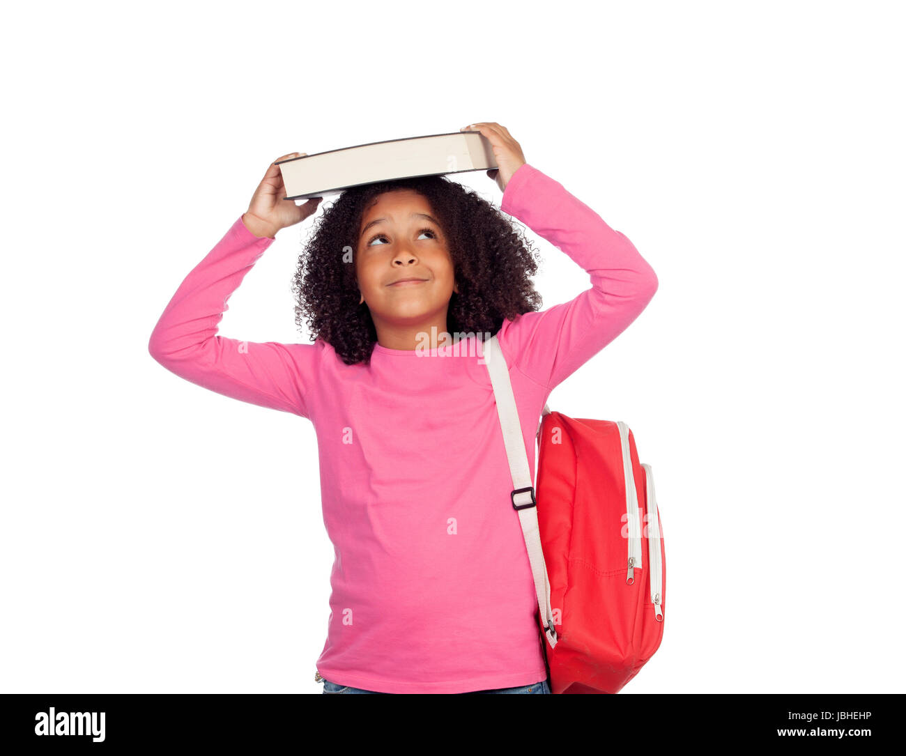 Little student girl with a book on her head isolated on a white ...