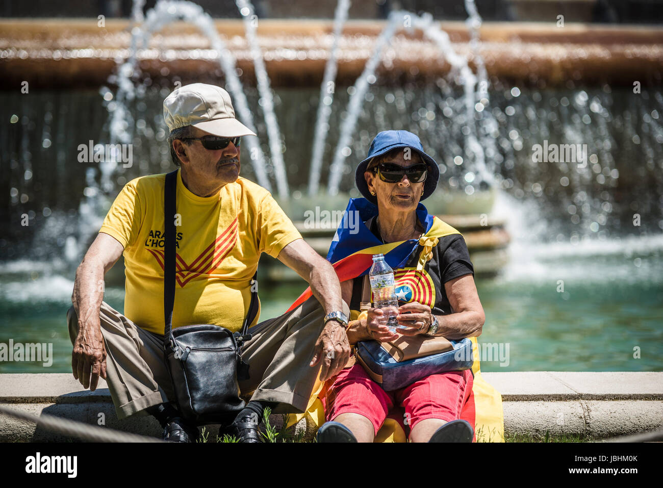 Barcelona, Spain. 11 June, 2017:  An elderly couple in Catalan colors take a rest after a pro-independence act at Barcelona's Montjuic Fountains in support of the recently announced referendum over Catalonia's independence from Spain in form of a republic at October 1st Credit: Matthias Oesterle/Alamy Live News Stock Photo