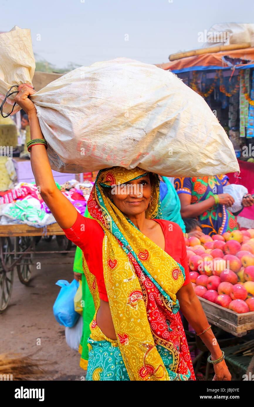 Local woman carrying bag on her head at Kinari Bazaar in Agra, Uttar Pradesh, India. Agra is one of the most populous cities in Uttar Pradesh Stock Photo