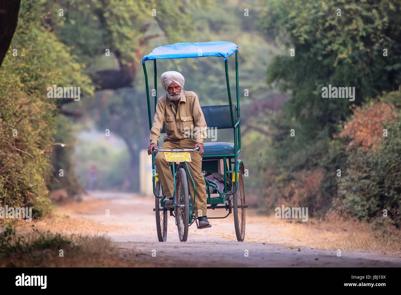 Cycle rickshaw riding in Keoladeo Ghana National Park in Bharatpur, Rajasthan, India. The park was declared a protected sanctuary in 1971 and it is al Stock Photo