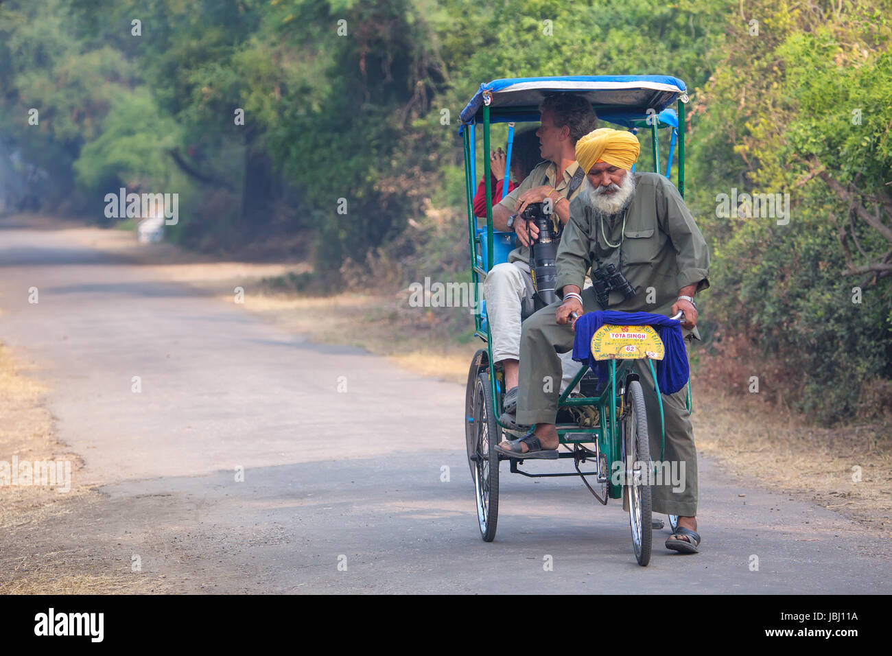 Visitors riding cycle rickshaw in Keoladeo Ghana National Park in Bharatpur, Rajasthan, India. The park was declared a protected sanctuary in 1971 and Stock Photo