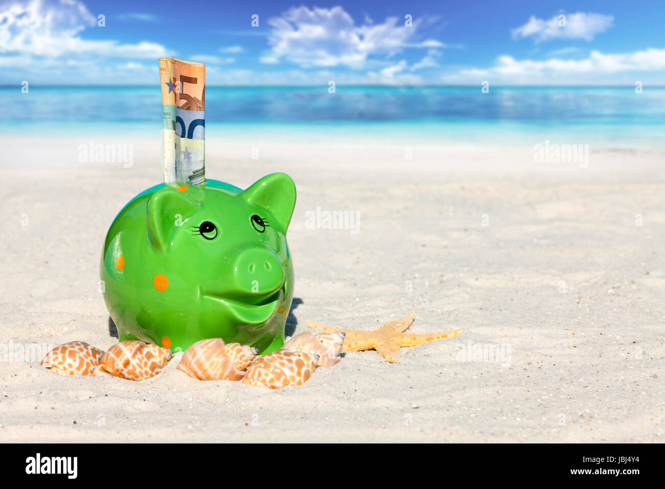 Sparschwein mit Geldscheinen am Sandstrand Stock Photo