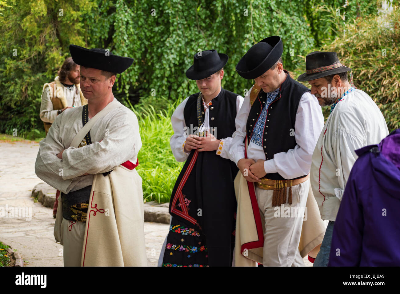 PIESTANY, SLOVAKIA – MAY 20 2017: Four unidentified men, dressed in folk costumes, seem to be unhappy and hard thinking about something (not shown wha Stock Photo