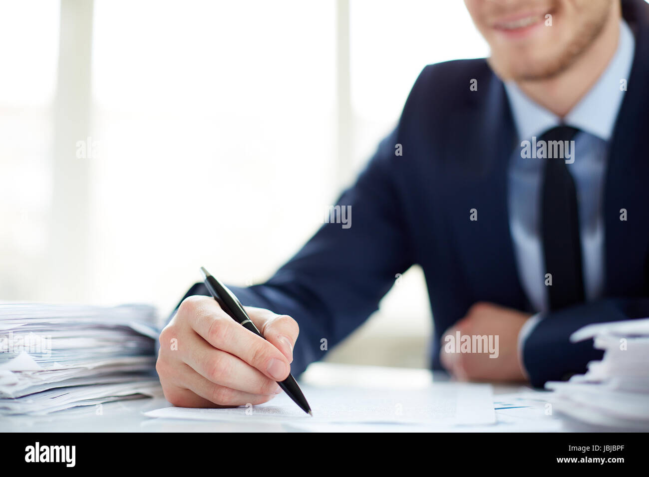 Hand of office worker with pen making notes Stock Photo - Alamy