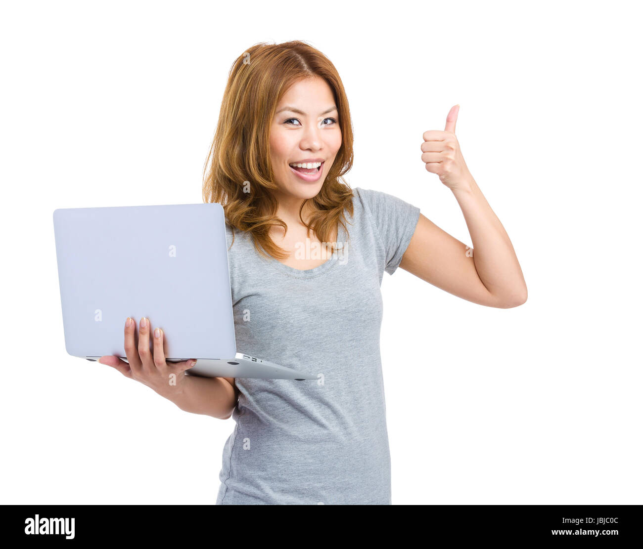 Young woman holding laptop making thumb up Stock Photo - Alamy