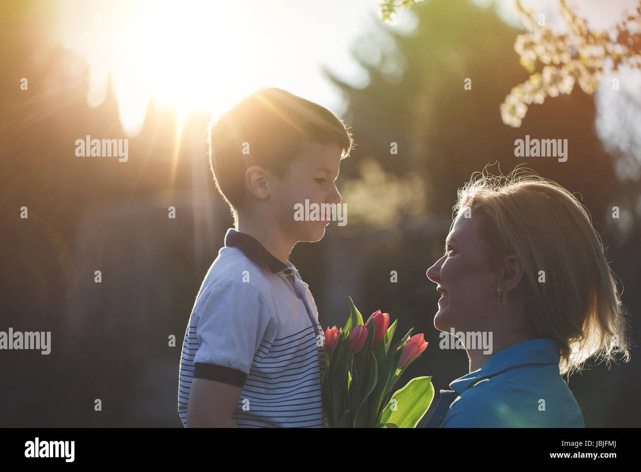 Happy mother with little son and tulips in sunset, Mother's day Stock Photo