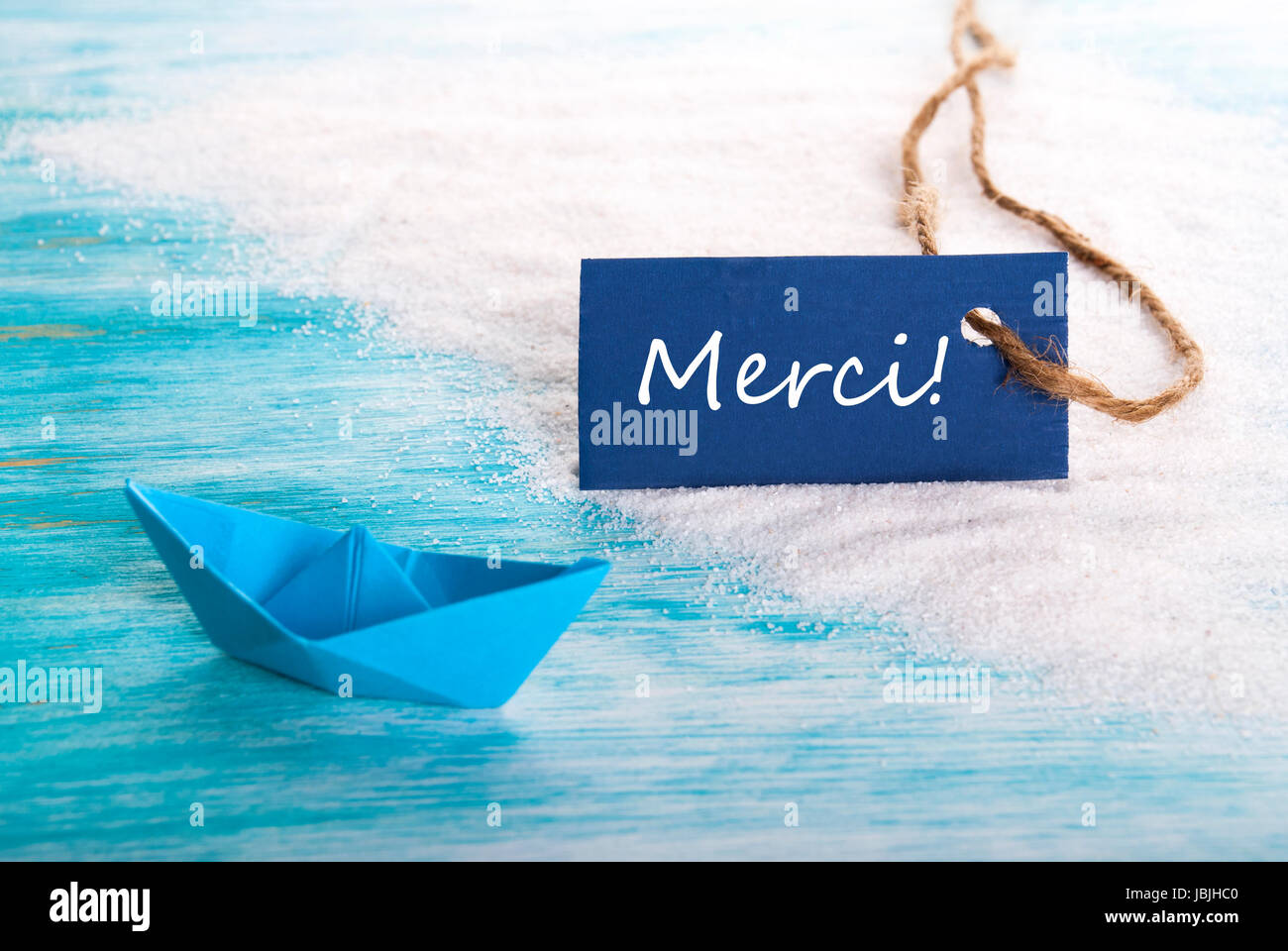 A Blue Tag with the French Word Merci which means Thanks ...