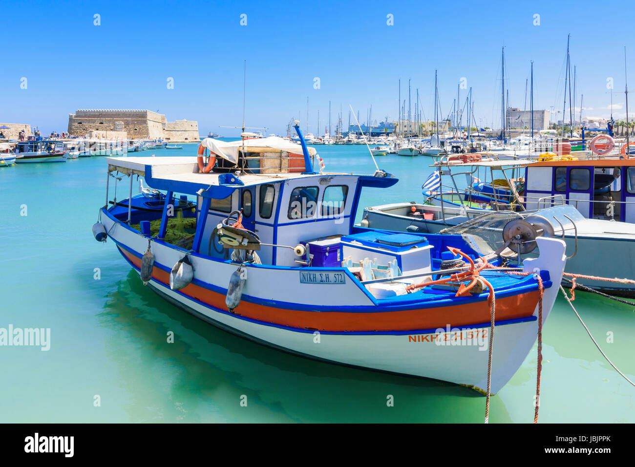 Fishing boats moored in the inner harbour with the Koules Fortress in the background, Heraklion, Crete, Greece Stock Photo