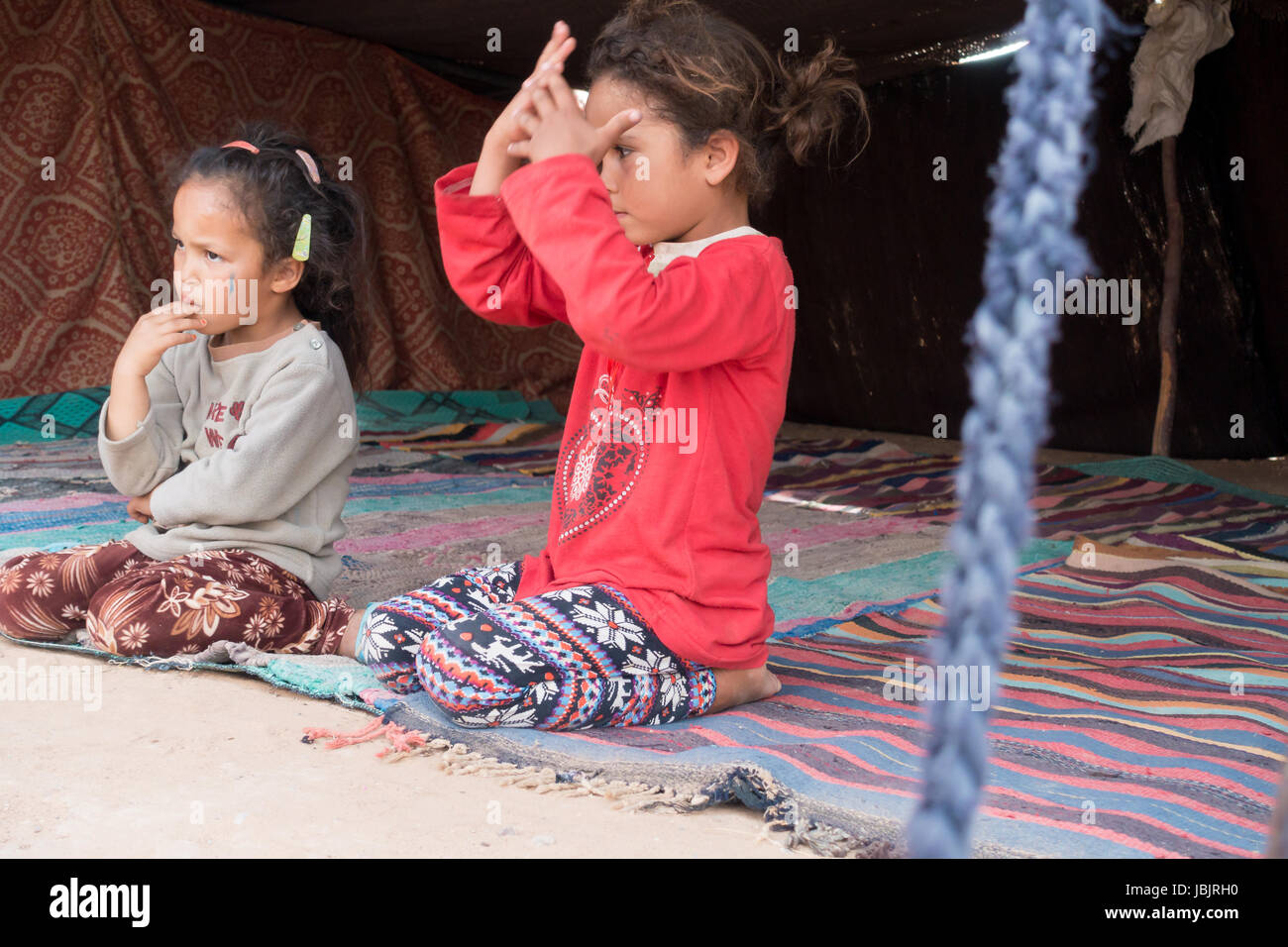 Merzouga Desert, Morocco -  May 09, 2017: Two young Moroccan Berber girls sitting in a Berber tent in the Sahara desert. Stock Photo