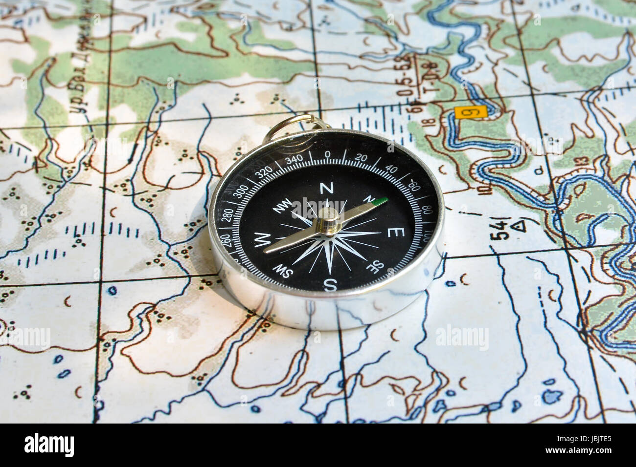 Compass on the map. Navigation tools to avoid getting lost. Stock Photo