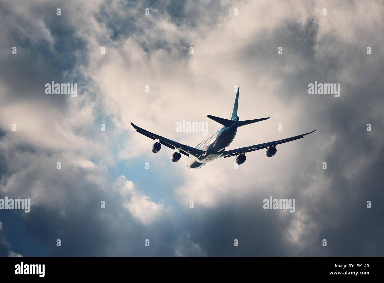 Flight in bad weather. Airplane flying under dramatic storm clouds. Stock Photo