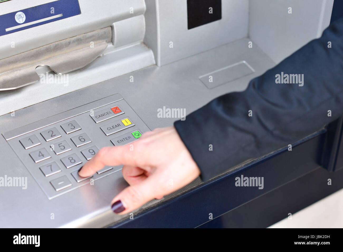 Woman hand entering code into atm machine Stock Photo - Alamy