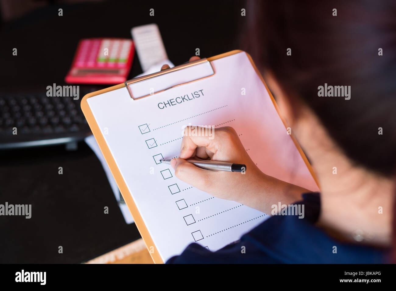 image of businessfemale preparing checklist at office desk Stock Photo