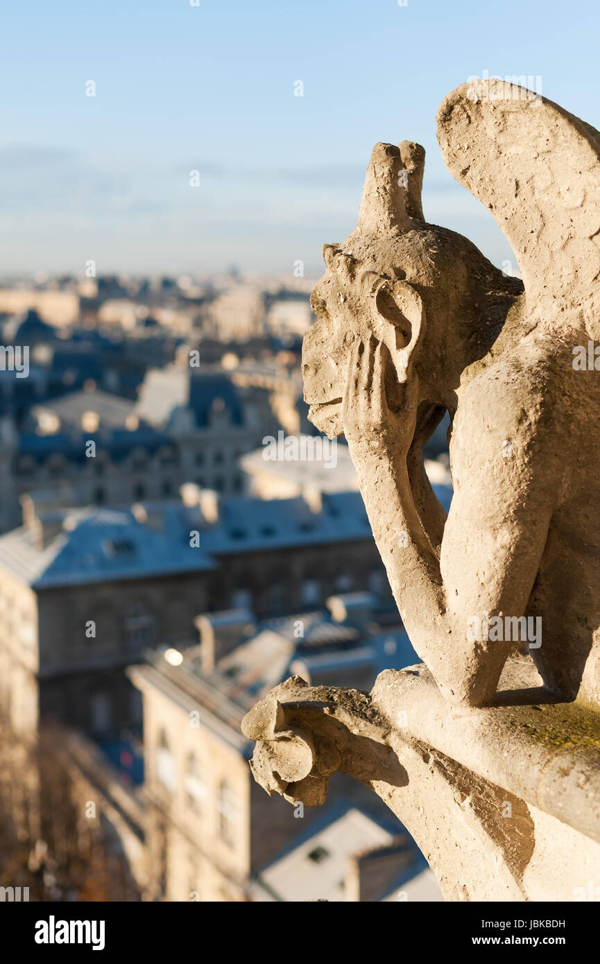 Gargoyle watching the roof of Paris, France - Vertical view Stock Photo