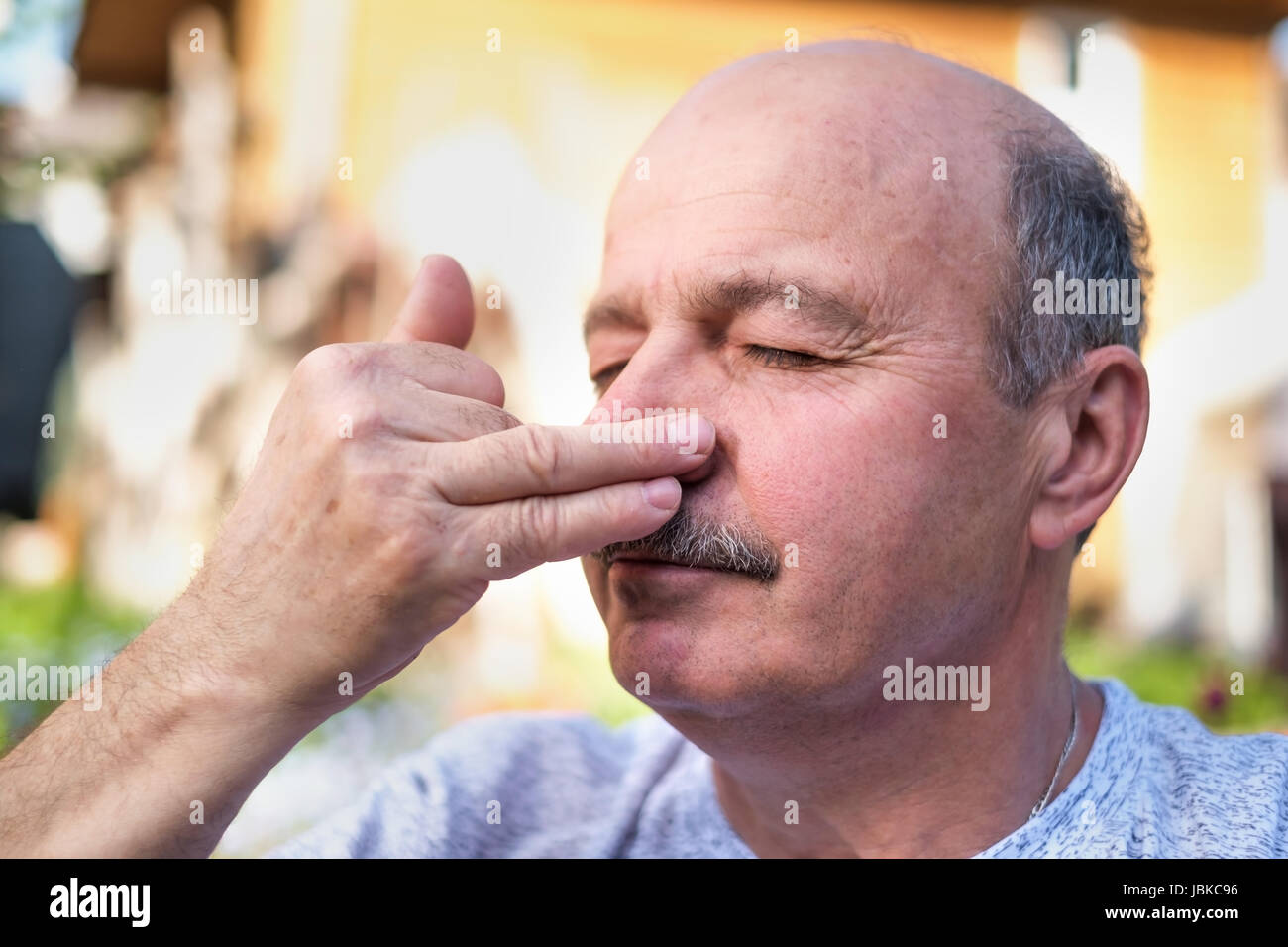 Handsome mature man with mustache breathing yoga pranayama on summer sunny day outside. Stock Photo