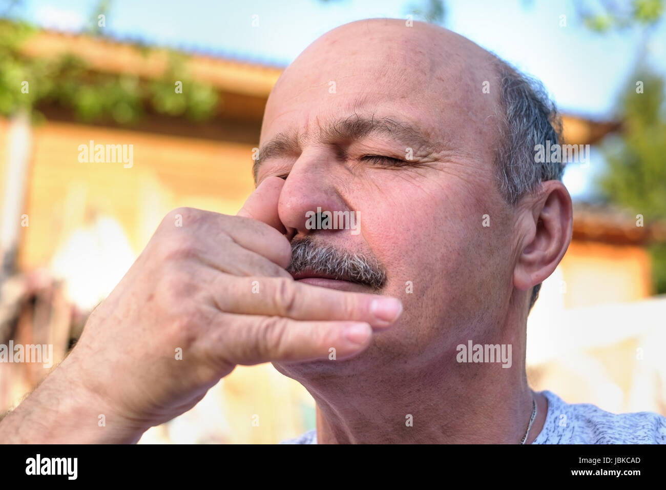 Handsome mature man with mustache breathing yoga pranayama on summer sunny day outside. Stock Photo
