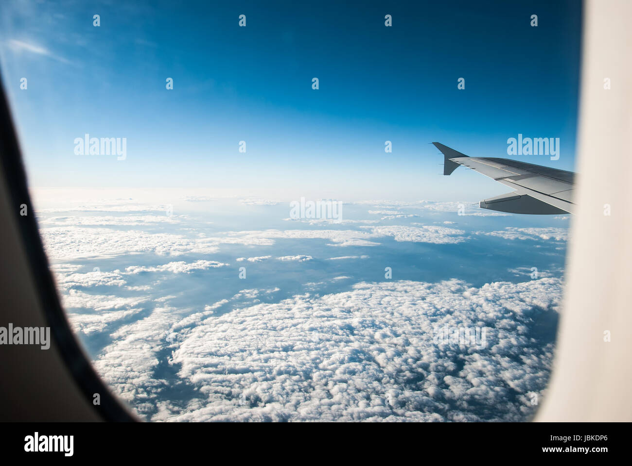 view from an airplane above the clouds Stock Photo