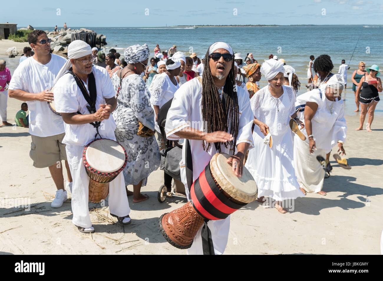 Descendants of enslaved Africans brought to Charleston in the Middle Passage hold a procession to honor their relatives lost during a remembrance ceremony at Fort Moultie National Monument June 10, 2017 in Sullivan's Island, South Carolina. The Middle Passage refers to the triangular trade in which millions of Africans were shipped to the New World as part of the Atlantic slave trade. An estimated 15% of the Africans died at sea and considerably more in the process of capturing and transporting. The number of African deaths attributable to the Middle Passage voyage is estimated at 2 million. Stock Photo