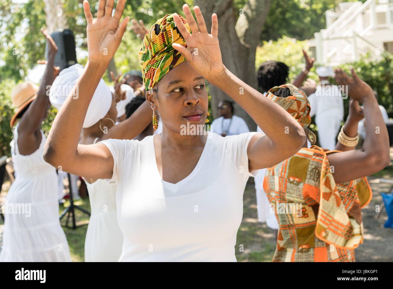 Descendants of enslaved Africans brought to Charleston in the Middle Passage dance to honor their relatives lost during a remembrance ceremony along the saltwater marsh June 10, 2017 in Sullivan's Island, South Carolina. The Middle Passage refers to the triangular trade in which millions of Africans were shipped to the New World as part of the Atlantic slave trade. An estimated 15% of the Africans died at sea and considerably more in the process of capturing and transporting. The total number of African deaths directly attributable to the Middle Passage voyage is estimated at up to two million Stock Photo