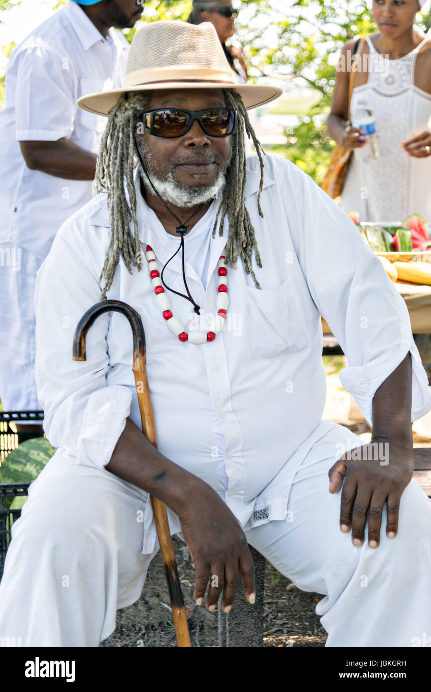 A descendant of enslaved Africans brought to Charleston in the Middle Passage rests during a remembrance ceremony at Fort Moutrie National Monument June 10, 2017 in Sullivan's Island, South Carolina. The Middle Passage refers to the triangular trade in which millions of Africans were shipped to the New World as part of the Atlantic slave trade. An estimated 15% of the Africans died at sea and considerably more in the process of capturing and transporting. The total number of African deaths directly attributable to the Middle Passage voyage is estimated at up to two million African deaths. Stock Photo